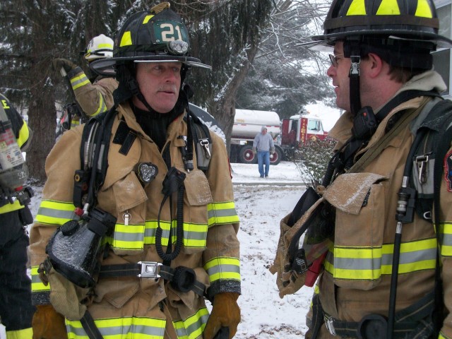 Firefighters Jay McKinney and Scott Wisner chatting after a building fire on West Branch Road.